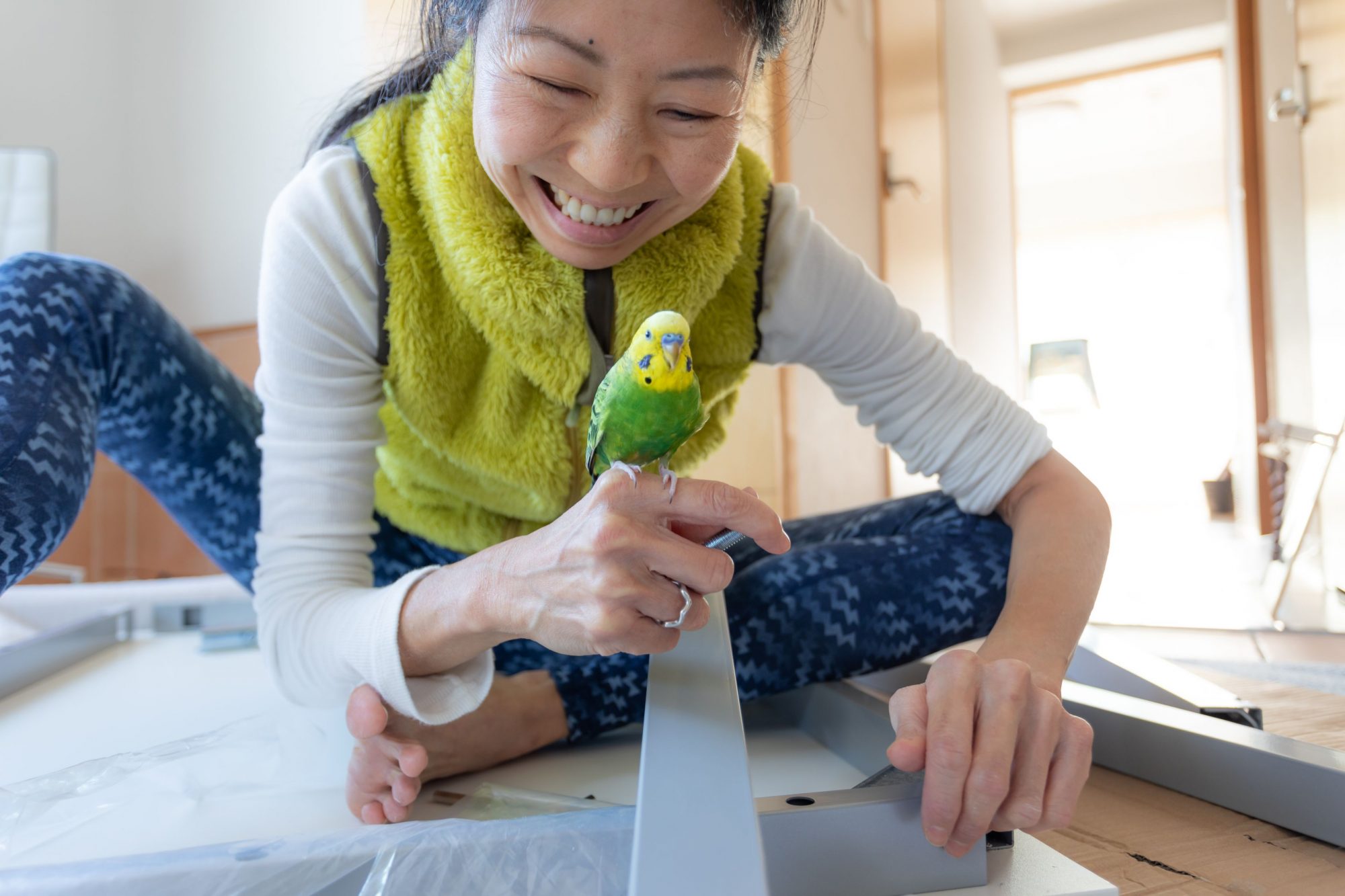 A girl plays with a pet bird.